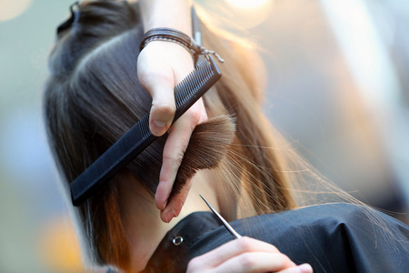 在理发店主剪头发和胡须的男子在理发店里男人的发型师在理发店理发