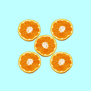 彩色水果图案的新鲜橙色切片在蓝色背景。从顶部视图