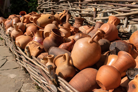 许多陶瓷手工器皿, 粘土制成, 挂在树篱围栏上