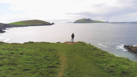 女孩站在爱尔兰西海岸悬崖的边缘