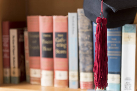 黑色毕业帽和红色流苏放在书上