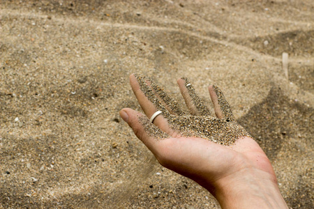 沙子从人的手在海滩跑下来
