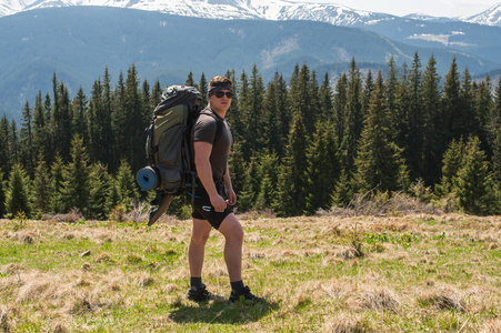 探险家站在绿色的山坡上, 欣赏着茂密的山丘伸展到地平线--令人敬畏的