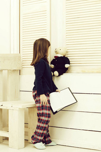 孩子或漂亮的女孩玩玩具熊和书图片