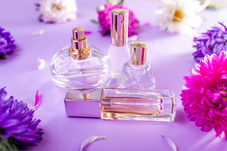 紫色和白色花的香水瓶在紫罗兰色背景下