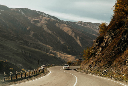 高高的高山和丘陵, 蜿蜒的道路上行驶着一辆小汽车, 美丽的风景