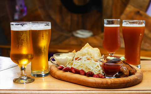 有啤酒小吃的木板.在木桌上照片