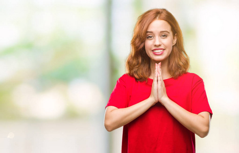 年轻美丽的女人在孤立的背景祈祷双手一起请求原谅微笑自信