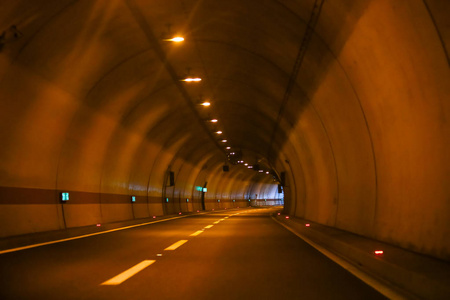 末端有出口的弯曲的空的公路隧道照片