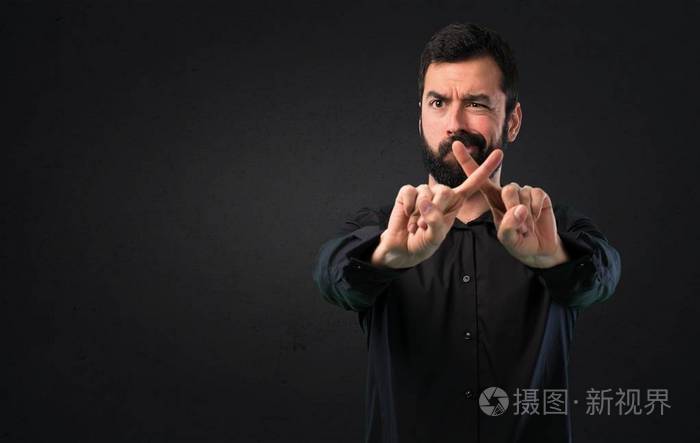 有胡子的英俊的人在黑色背景上没有手势