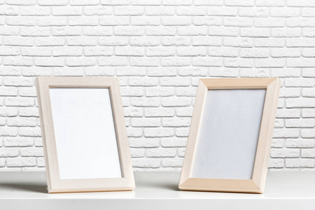 墙上空白的白色镜框和桌木