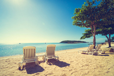 美丽的热带海滩和海与椅子在蓝天为旅行和假期