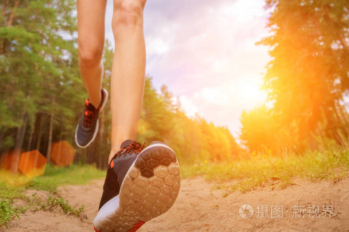 运动员在公园跑步的特写镜头.健身的女人慢跑在户外.