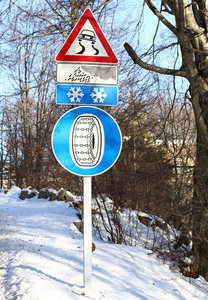 街道标志和道路在冬季滑和雪链的迹象