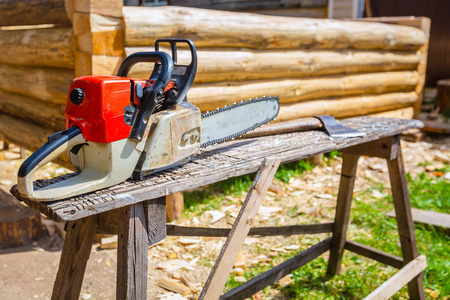 电锯和木制菜刀或斧头是用来建造木房子从木材松树和薄片在地面上