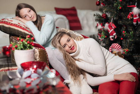 2女孩在白色壁炉旁边, 装饰圣诞树与玩具