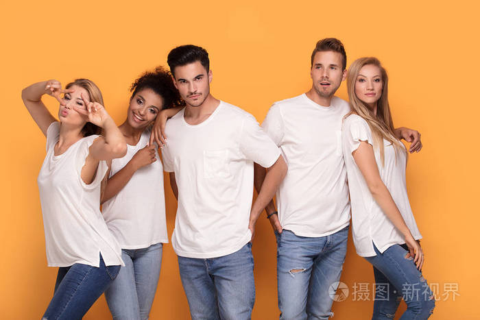 在橙色的工作室背景白色休闲衬衫上摆姿势