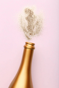 香槟酒瓶与粉红色的背景闪烁