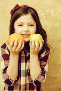 可爱的女孩，手里拿着桔子和苹果