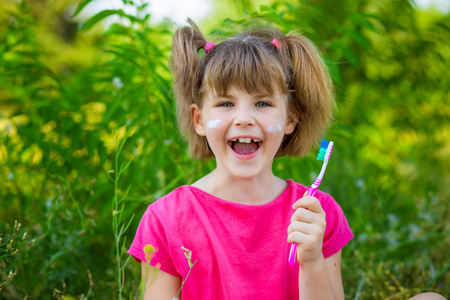 快乐的小女孩刷牙。牙科卫生。健康理念