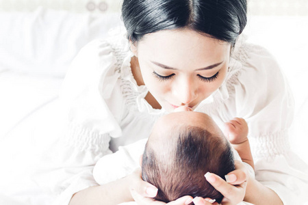 快乐家庭母亲亲吻婴儿图片