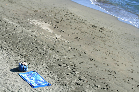 沙滩上的沙滩袋和毛巾, 有脚印