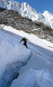 登山者在开始攀登阿尔卑斯山陡峭的冰雪北面时, 穿过一个又大又深的裂缝 bergschrund