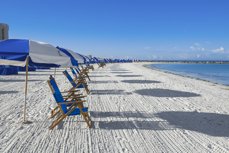 大量的日光躺椅和海滩伞上银砂 度假概念