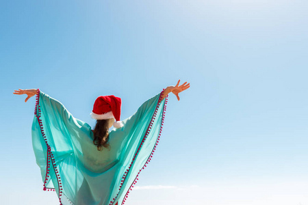 自由的女人与圣诞帽在自由幸福的喜悦在海滩上。复制空间
