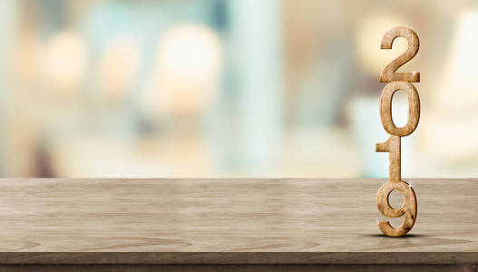 新年2019木头数字 3d 渲染 在木桌在模糊抽象散景光背景, 模仿横幅空间为陈列或蒙太奇产品, 节日庆祝问候卡片