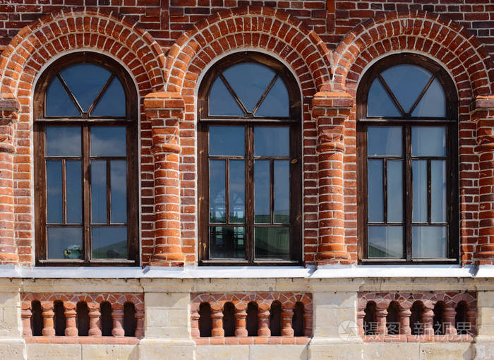 旧的红砖建筑的墙上有三窗口以拱的形式
