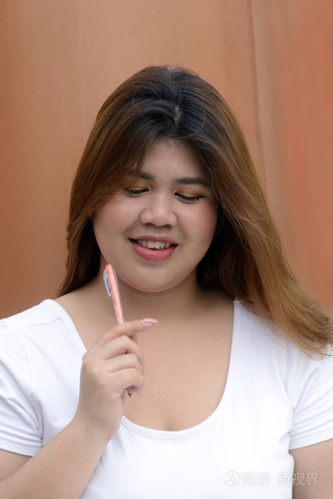 亚洲俏丽的笑脸面孔肥胖妇女公园杆群的姿态与思考