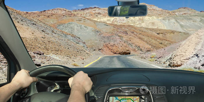 在加州的死亡谷, 在岩石中驾驶一辆汽车向一条偏僻的道路驶去