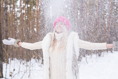 愉快的年轻妇女玩雪在雪地森林户外