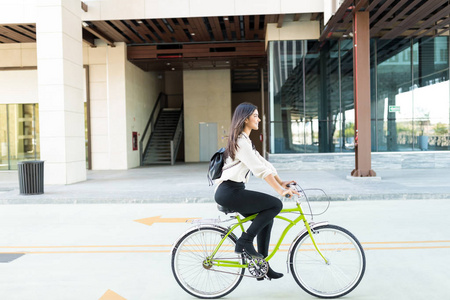 女性职业骑自行车保护城市环境图片