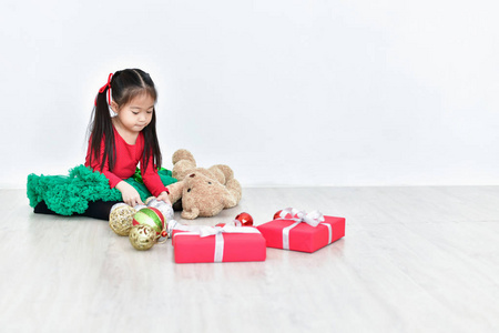 小女孩庆祝圣诞节与红色圣诞老人礼服