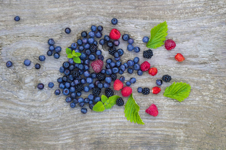 蓝莓, 黑莓, 树莓混合在老木桌背景上
