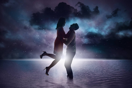 浪漫的亚洲情侣微笑着凝视着海滩上的对方照片