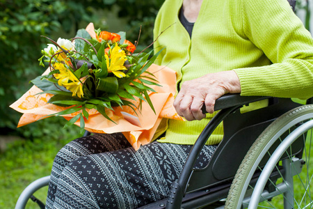 老年瘫痪妇女收到鲜花花束护理家户外