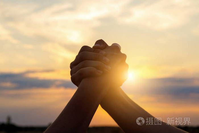 两个人的手在蓝天上摇晃