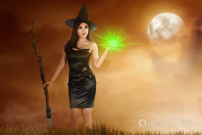 漂亮的亚洲女巫, 手上有扫帚和魔法火.万圣节概念