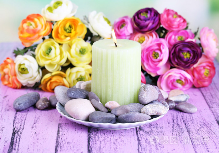 spa 石块, 蜡烛和鲜花颜色木制的桌子,在明亮的背景上的组成