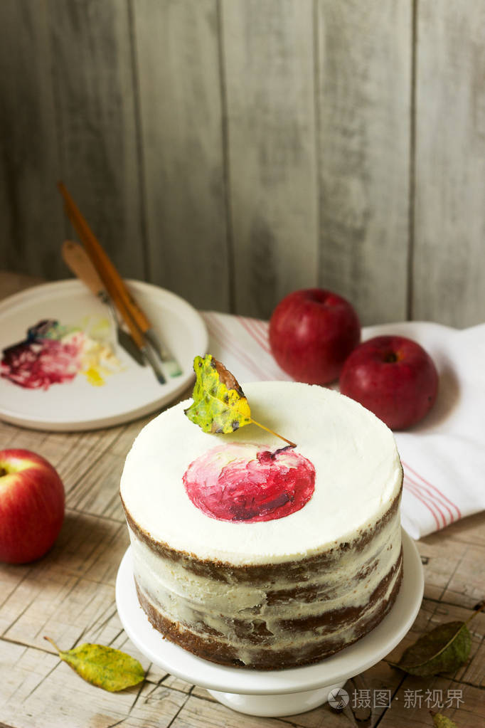 苹果蛋糕用凝乳膏在秋季构图的背景下用彩绘苹果装饰质朴风格选择性