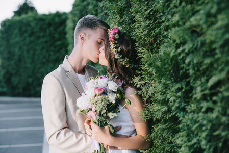 美丽的婚礼情侣亲吻和举行花卉花束