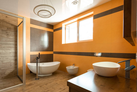 浴室内的橙色和白色的浴缸, 水槽和坐浴盆