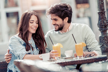 可爱的情侣在咖啡馆可爱的情侣约会在咖啡馆喝一杯橙汁照片