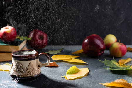 秋天的作文有雨。蒸咖啡杯, 秋叶, 罗恩, 苹果和书在雨天背景。秋天背景与舒适的气氛