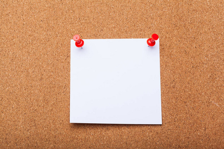 软木板上的空白便条纸照片