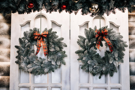 圣诞快乐, 新年愉快。时尚的假日装饰。圣诞节贺卡的背景。白色的门上的云杉花环