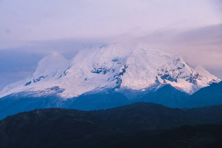 白雪皑皑的山顶在紫色的色调。秘鲁